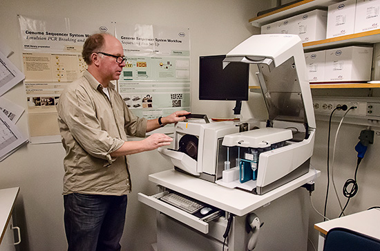 En person står framför ett laboratorieinstrument.