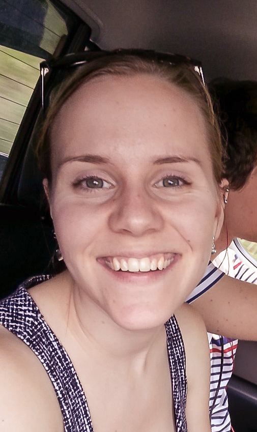Portrait of a smiling person in a car.