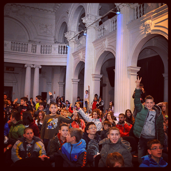 Publik bestående av barn i en stor aula.