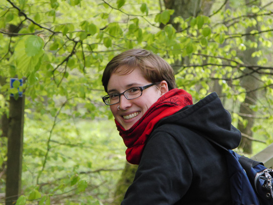 A portrait of a smiling person outside in the woods.