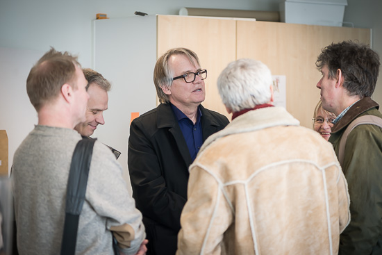 Six people is standing in a circle talking.