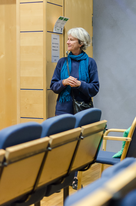 En person står vid sidan av i en föreläsningssal och pratar.