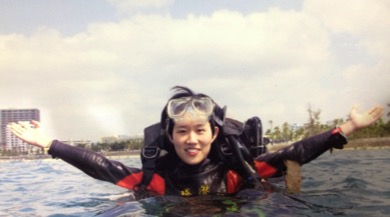 A person is standing in diving equipment in water.