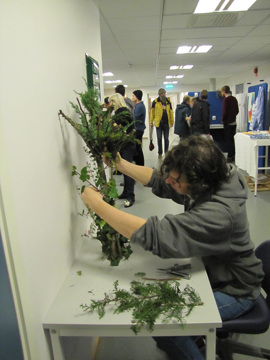 A person is arranging green twigs.