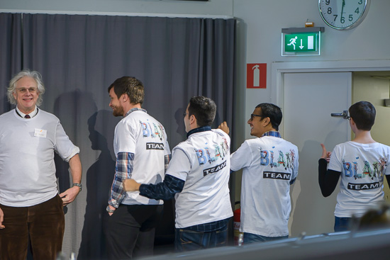 Five people are showing their t-shirts.