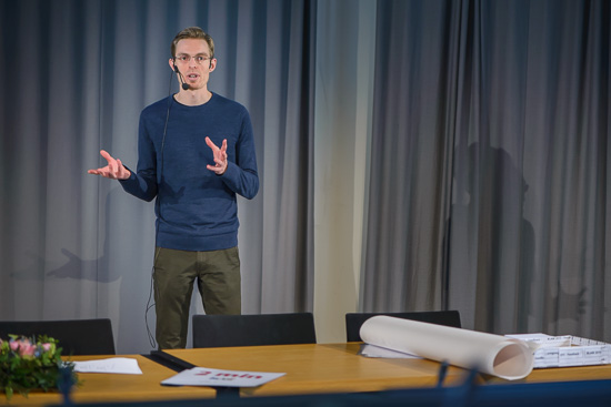 A person is standing talking in a lecture hall.