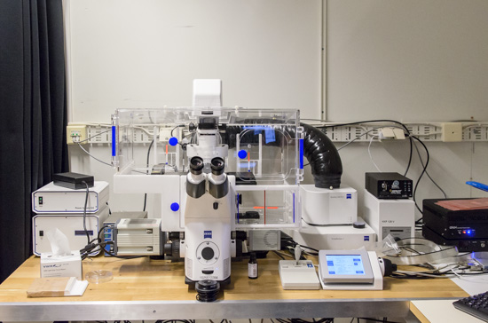A large microscope with its equipment is standing on a lab bensch.