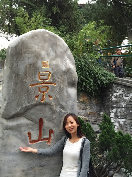 One person is standing in front of a stone with Chinese signs.