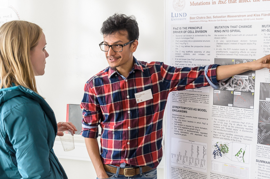 Two persons discuss a scientific poster. Photo.