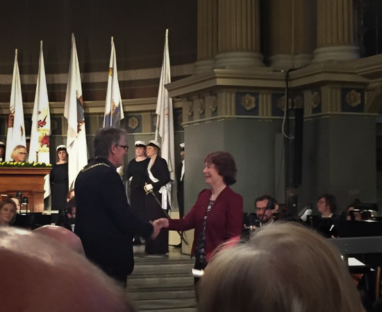 Two persons shake hands in the University hall.