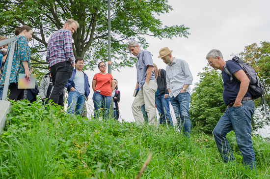 Some persons stands looking down at the grass.