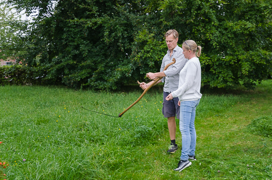 Two persons stand with a scyte.