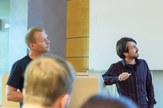 Two persons stand looking up in a lecture hall.