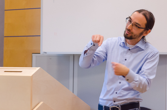 A person is gestaculating behind a podium