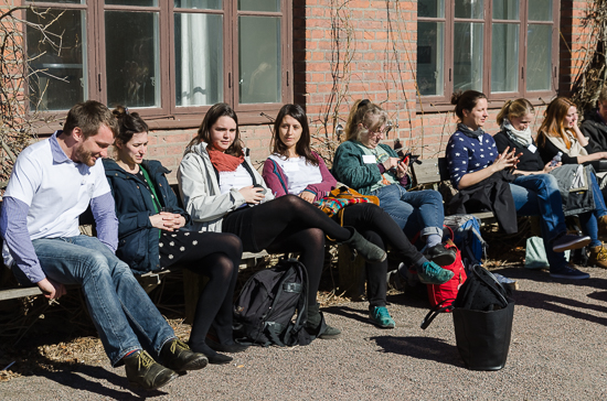 Some persons are sitting outside in the sun.