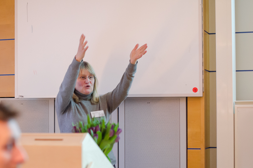 A person is standing with her arms above her head.