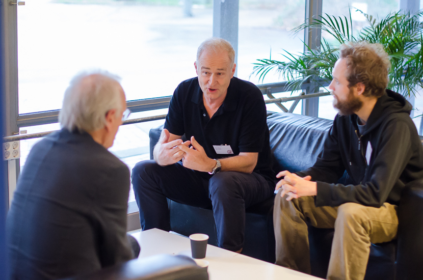 Three persons are sitting talking.