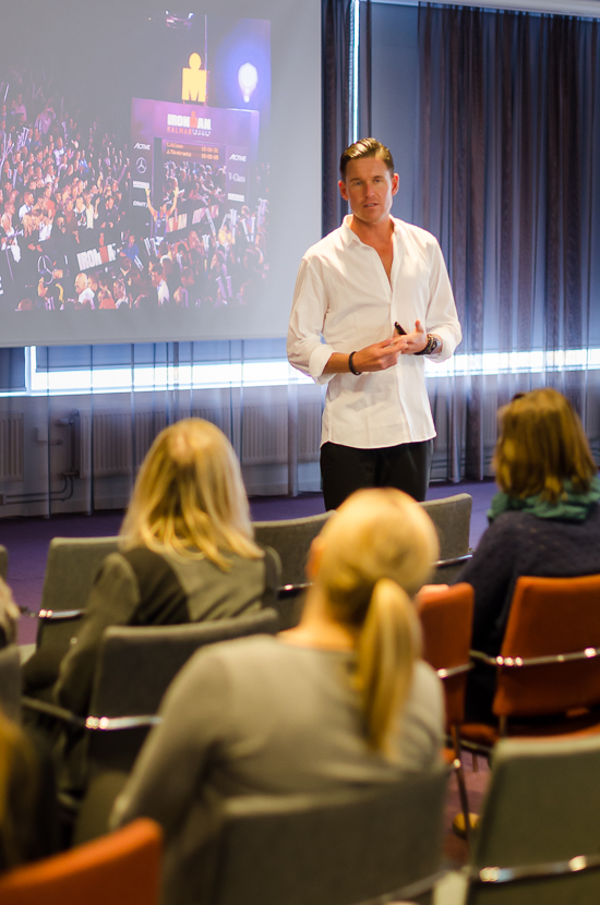 A person is standing in front of an audience.