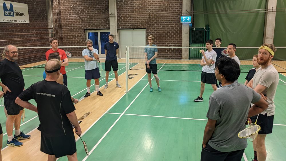 Some people are standing in a gym hall. Photo.