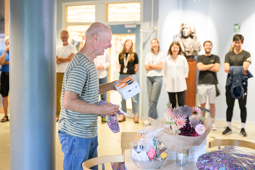 En person håller i ett paket. Foto.